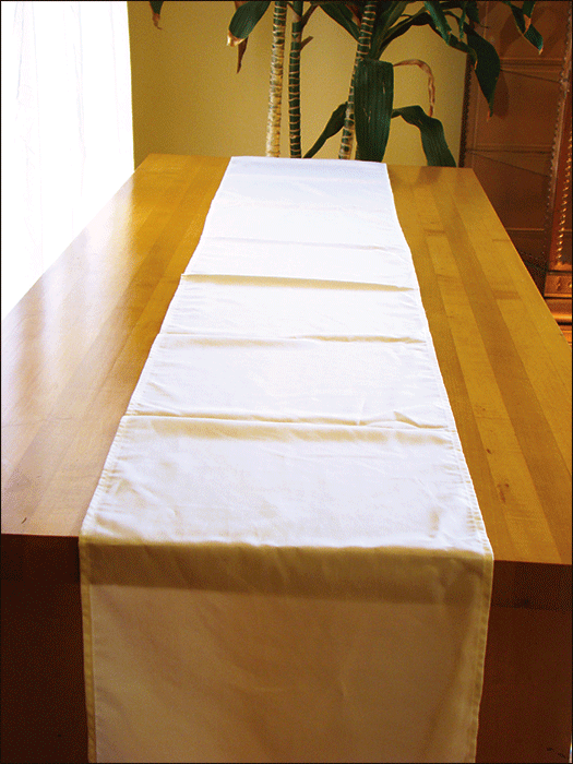 White natural fabric table runner on wooden table for decorating